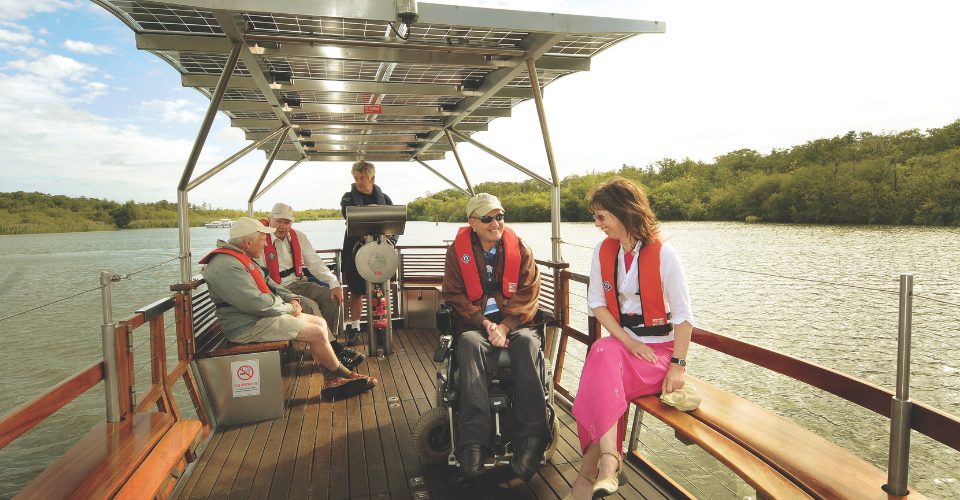 Boating and sailing in norfolk group of people on a solar powered boat The Broads 960px w x 640px h
